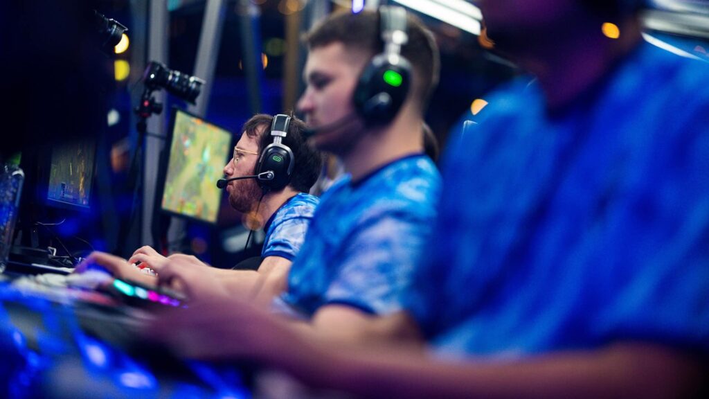 A imagem mostra jogadores da equipe Tundra Esports participando de uma competição de esports. Eles estão jogando Dota 2