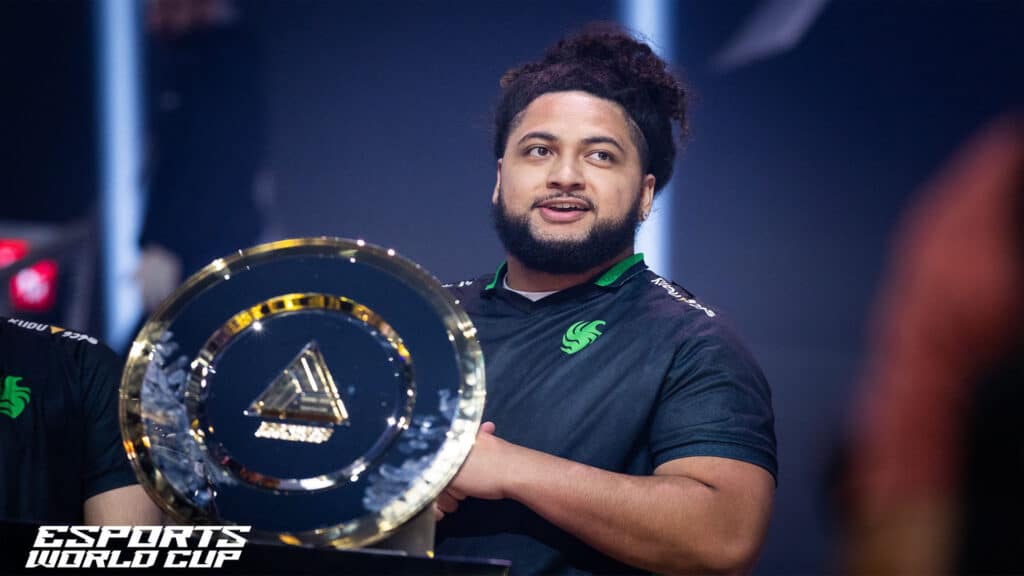 Image of Warzone player Hisoka standing near Esports World Cup trophy