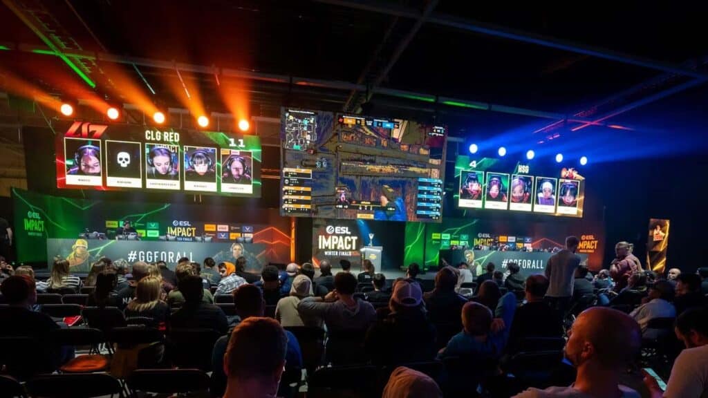 Dargestellt ist ein Live-E-Sport-Event, insbesondere ein Counter-Strike 2 (CS2)-Turnier für Frauen, Teil der ESL Impact League. Bei der Veranstaltung handelt es sich um einen professionellen, rein weiblichen Wettbewerb, der Teil der #GGFORALL-Initiative zur Förderung von Vielfalt und Inklusion in der E-Sport-Szene ist