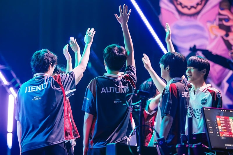 Image of the EDward Gaming VALORANT team in a huddle onstage during the VALORANT Masters London tournament at the Copper Box Arena.
